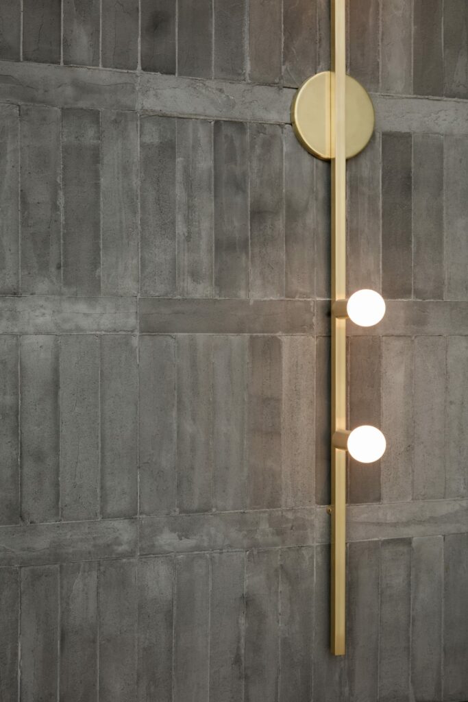 Raw concrete bricks combined with refined brass wall lights